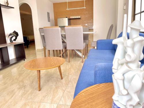 a living room with a blue couch and a table at Beautiful 2 bedroom, pool, beach in Manta