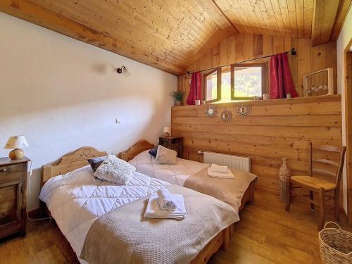 1 Schlafzimmer mit 2 Betten in einem Holzhaus in der Unterkunft Chalet spacieux avec sauna, proche des Menuires et St Martin de Belleville - FR-1-344-738 in Saint-Marcel