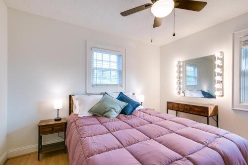 uma grande cama rosa num quarto branco com uma ventoinha de tecto em Serene Mill Spring Getaway with Yard and Fire Pit! em Mill Spring