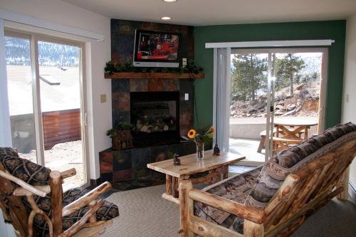 ein Wohnzimmer mit 2 Stühlen und einem Kamin in der Unterkunft Lazy R Cottages- 16B cabin in Estes Park