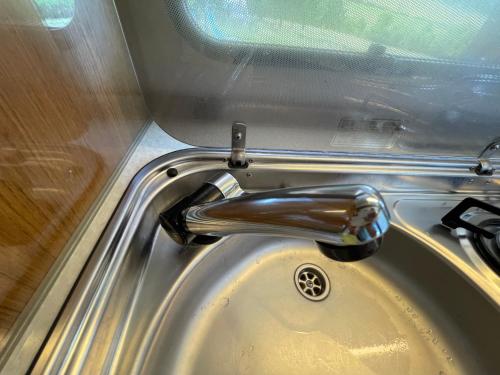 a chrome sink with a faucet in a bathroom at Zážitkový pobyt v luxusnom karavane vo Farmárskom Parku in Stožok