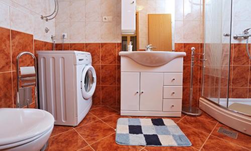 a bathroom with a washing machine and a sink at Apartment Fila i Jure in Solin