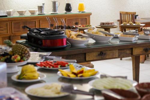 a buffet with many plates of food on a table at Pousada do Albatroz in Cabo Frio