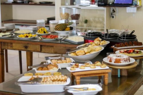 a buffet filled with lots of different types of food at Pousada do Albatroz in Cabo Frio