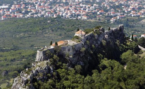 a castle on a mountain with a city in the background at Apartment Fila i Jure in Solin