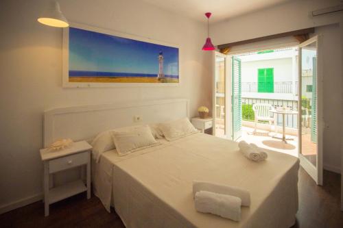 a bedroom with a bed, table and window at Hostal Sunset Ibiza in San Antonio