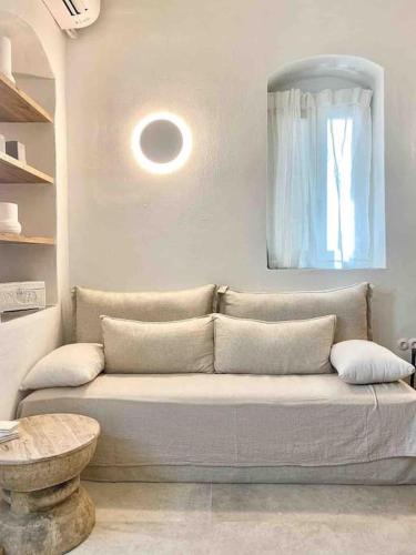 a living room with a couch and a mirror at Dee House Sifnos in Sifnos