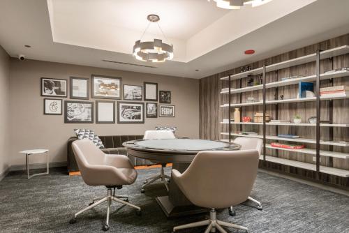 a room with a table and chairs and bookshelves at Experience Downtown Chicago at Millennium - Luxury Apartments in The Loop in Chicago