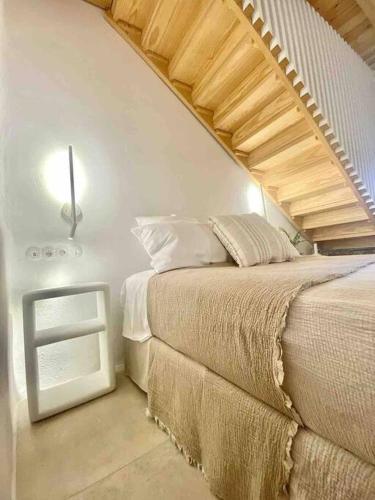 a bedroom with a bed and a stair case at Dee House Sifnos in Sifnos