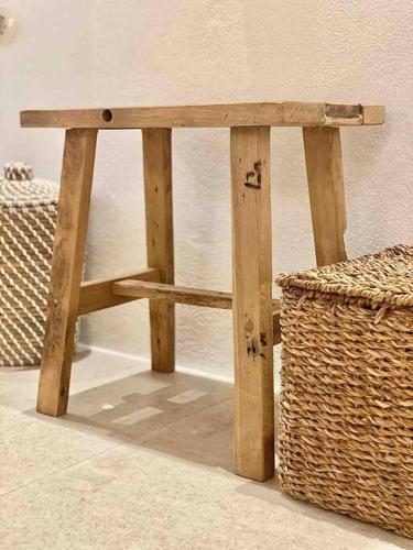 a wooden bench sitting next to a basket at Dee House Sifnos in Sifnos