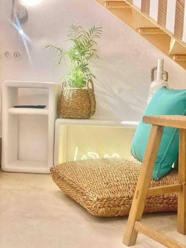 a room with a chair and a potted plant at Dee House Sifnos in Sifnos