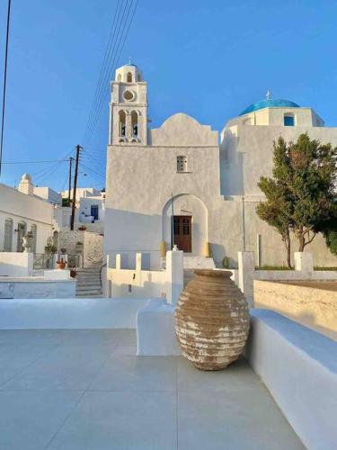 a building with a vase sitting in front of it at Dee House Sifnos in Sifnos