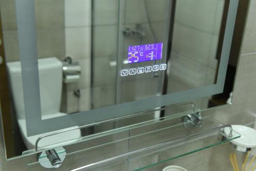 a mirror in a bathroom with a clock on it at Aljoša Luxury Apartment in Jagodina