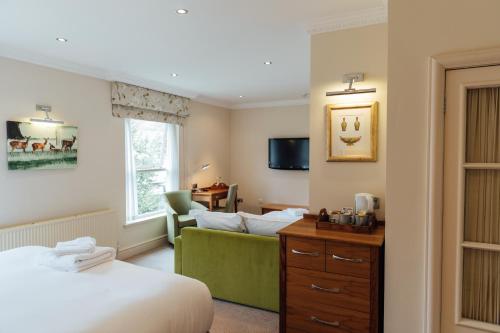 a hotel room with a bed and a couch at The Woburn in Woburn