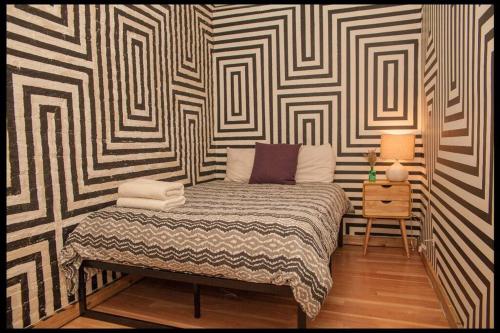 a bedroom with a bed in a room with a wall at Artistic 2BR in NYC in New York