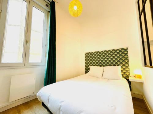 een slaapkamer met een wit bed en een raam bij Lodge Cassard in Nantes
