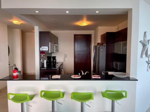 a kitchen with green stools at a counter at 14F Luxury Resort Lifestyle Ocean Views in Playa Bonita Village