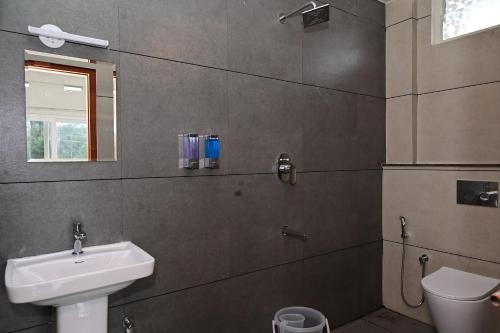 a bathroom with a sink and a toilet at Grand Misty Heaven in Madikeri
