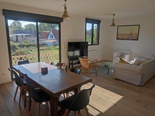 un salon avec une table et des chaises en bois dans l'établissement apatam, à Petit-Berneval