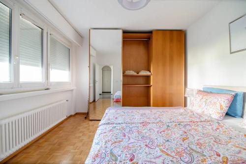 una camera con un letto e una grande finestra di Lugano Ferienwohnung nähe vom See mit Swimmingpool & Sauna a Paradiso