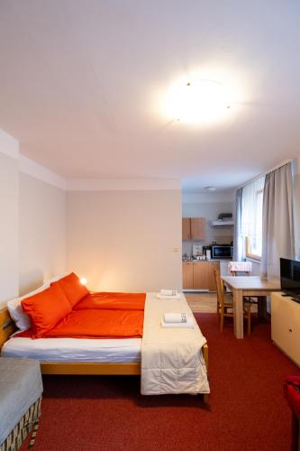 a bedroom with a bed and a desk and a kitchen at Guesthouse Rose in Sarajevo