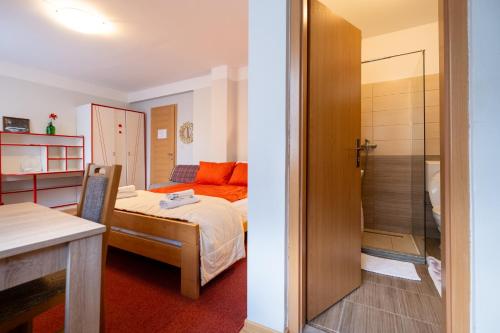 a small room with a bed and a glass door at Guesthouse Rose in Sarajevo