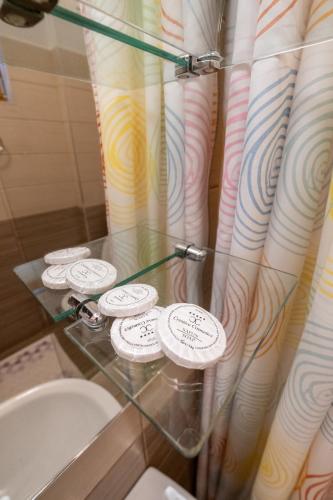 a glass counter in a bathroom with a toilet and curtains at Guesthouse Rose in Sarajevo
