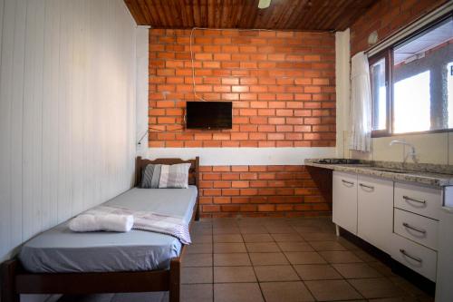Habitación con 2 camas y pared de ladrillo en Pousada Natureza, en Florianópolis
