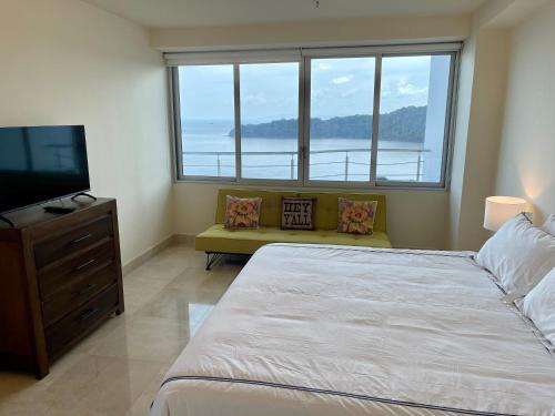1 dormitorio con 1 cama y TV de pantalla plana en 14F Luxury Resort Lifestyle Ocean Views, en Playa Bonita Village