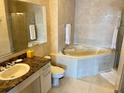 ein Badezimmer mit einem Waschbecken, einer Badewanne und einem WC in der Unterkunft 14F Luxury Resort Lifestyle Ocean Views in Playa Bonita Village