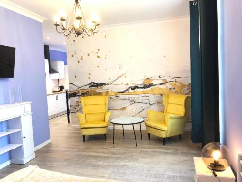 a living room with two yellow chairs and a table at Suite Bubbles Spa - Luxe - Centre Ville - calme - wifi in Troyes