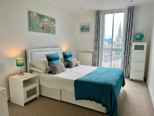 a bedroom with a bed and a large window at Bedford Central Apartment with Free Secure Parking in Bedford