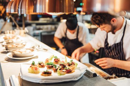 two chefs preparing a plate of food in a kitchen at The Woburn in Woburn