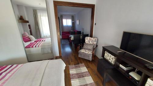 a living room with a bed and a mirror at Titi Boutique Apartmanok in Bükfürdő