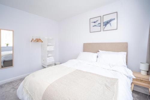 a white bedroom with a bed and a mirror at Spacious 5 Bedroom House - Sleeps 7 - 3-Car Driveway - Work - Leisure in Wolverhampton