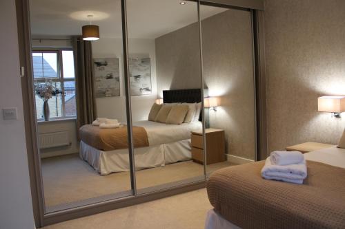 een slaapkamer met een grote spiegel en een bed bij Haven - Spacious Luxury Home perfect for families, couples and contractors! 5mins to Xscape and Junction 32! in Castleford