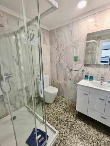 a bathroom with a shower and a toilet and a sink at Apartamentos Sol Mar in Los Cristianos