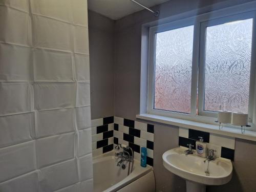 a bathroom with a sink and a toilet and a window at Primos Place - 2 Bedroom in Ashington in Ashington