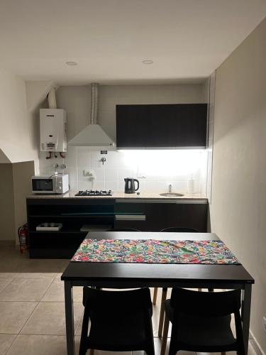 Una cocina con una mesa y dos sillas y una mesa y una cocina. en ESTEPA, en Río Gallegos