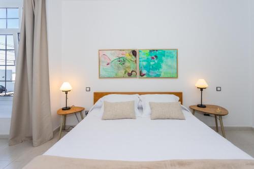 um quarto com uma grande cama branca e duas mesas em Villa Dulce Celestino Lanzarote em Nazaret