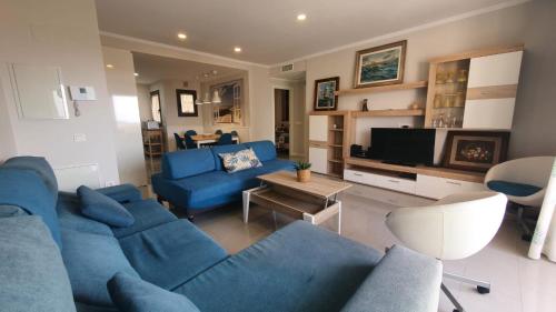 a living room with a blue couch and a tv at LA MARINA in Torre del Mar