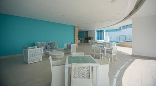 a room with tables and chairs and a blue wall at 14F Luxury Resort Lifestyle Ocean Views in Playa Bonita Village