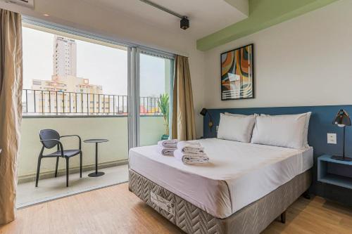 um quarto com uma cama grande e uma janela grande em 360 RBS Elíseos em São Paulo