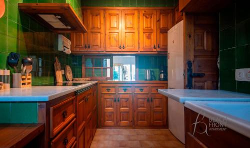 a kitchen with wooden cabinets and a blue counter top at BFA - R149 Casa adosada Alorda con piscina comunitaria in Calafell