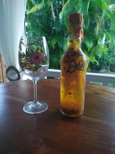 une bouteille et un verre de vin sur une table en bois dans l'établissement Bungalow dans Résidence Fleurie, à Saint-François