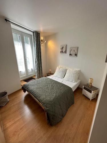 une chambre avec un lit et une grande fenêtre dans l'établissement Villa Duchatel Appt 2/4 pers, à Le Mont-Dore