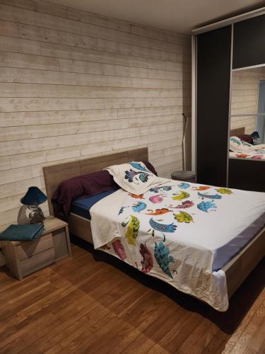 une chambre avec un lit avec une couette blanche dans l'établissement la chambre de Jeremy, à La Bachellerie