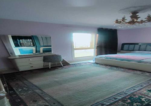 1 dormitorio con 1 cama, vestidor y ventana en شقة مفروشة بالتجمع الخامس, en El Cairo