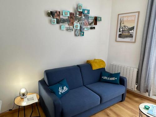 a blue couch sitting in a living room at Villa Duchatel Appt 2/4 pers in Le Mont-Dore