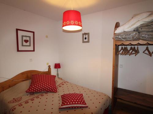 ein Schlafzimmer mit einem Bett mit roten Kissen und einer roten Lampe in der Unterkunft Appartement Lanslebourg-Mont-Cenis, 3 pièces, 6 personnes - FR-1-508-255 in Lanslebourg-Mont-Cenis